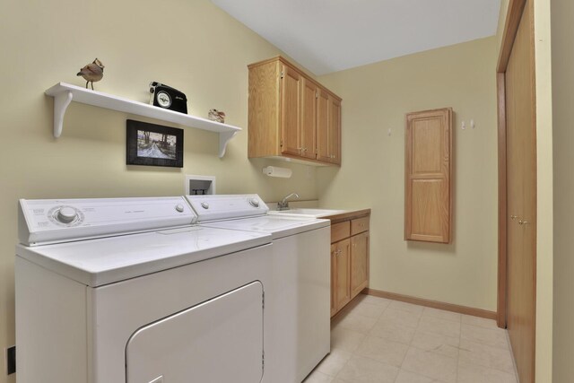 washroom with sink, cabinets, and washer and clothes dryer