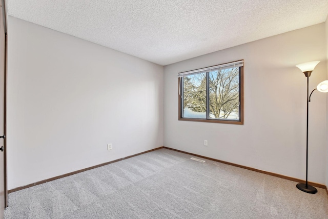 carpeted spare room with a textured ceiling