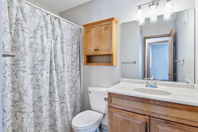 bathroom featuring vanity, toilet, curtained shower, and a textured ceiling