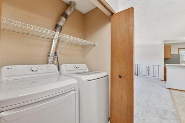 clothes washing area featuring light carpet and washer and clothes dryer