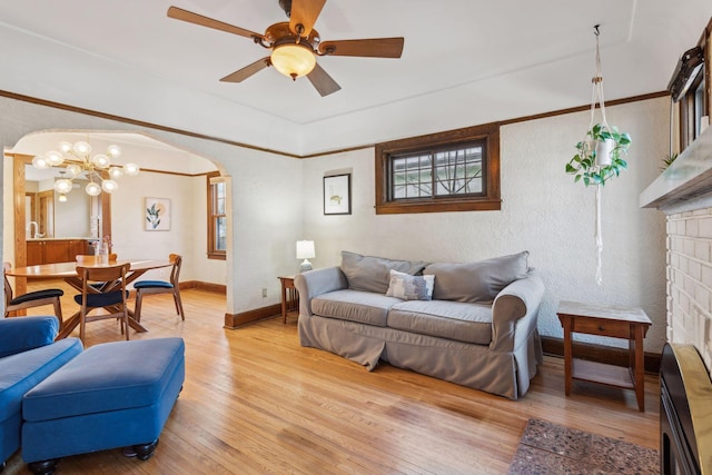 living room with crown molding, light hardwood / wood-style flooring, and ceiling fan