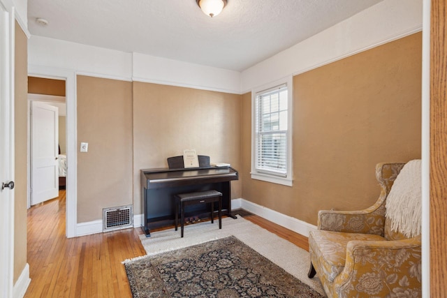 living area with wood-type flooring and a textured ceiling