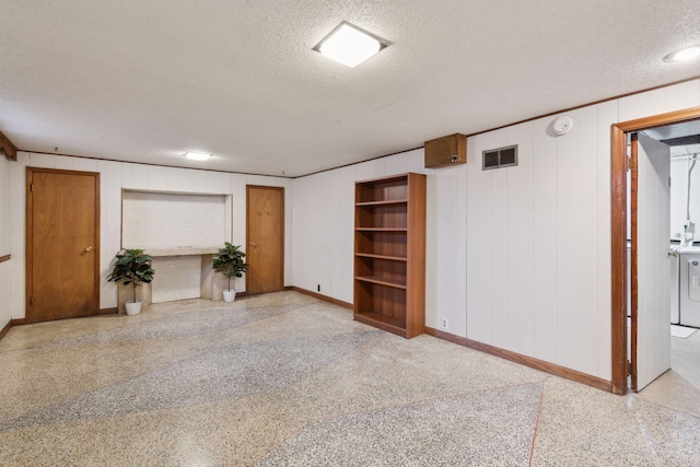 unfurnished living room with washer and clothes dryer and a textured ceiling