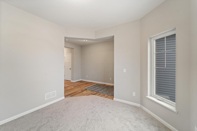 spare room featuring light carpet