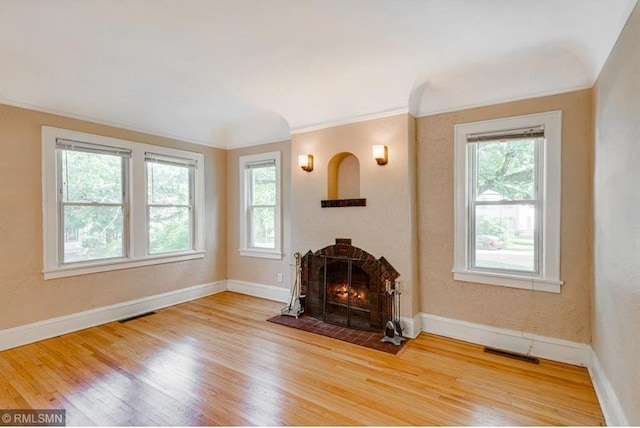 unfurnished living room with crown molding and wood-type flooring