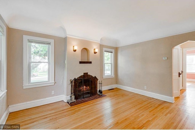 unfurnished living room with crown molding and light hardwood / wood-style flooring