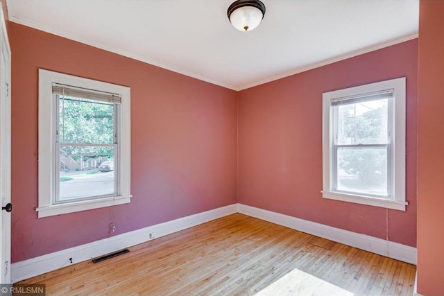 spare room with crown molding and light hardwood / wood-style flooring