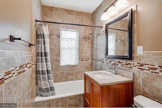 full bathroom with vanity, toilet, tile walls, and shower / bath combo