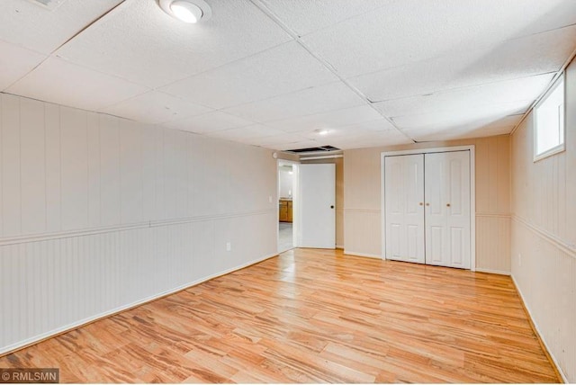 interior space with a drop ceiling and light wood-type flooring