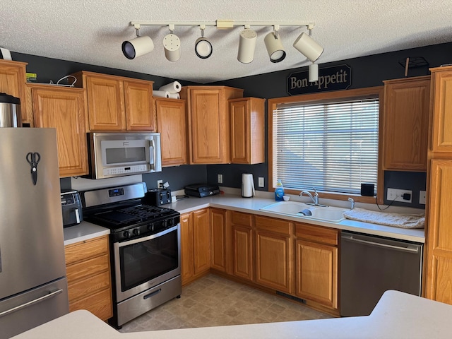 kitchen featuring sink, a textured ceiling, and appliances with stainless steel finishes