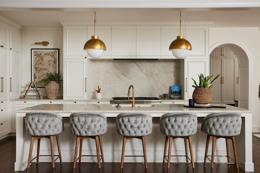 kitchen with decorative backsplash, sink, pendant lighting, and an island with sink