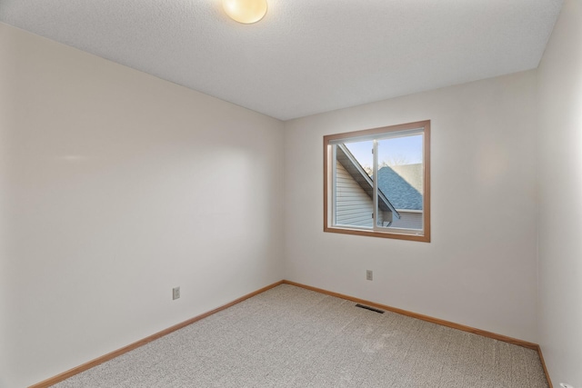 empty room featuring carpet and a textured ceiling