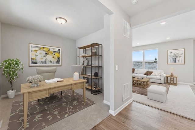 home office with visible vents, baseboards, and wood finished floors