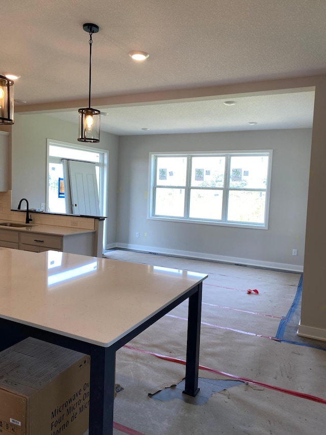 kitchen featuring pendant lighting, a center island, plenty of natural light, and sink