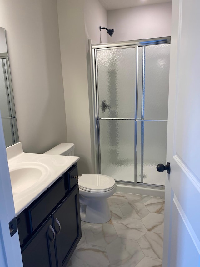 bathroom featuring an enclosed shower, vanity, and toilet