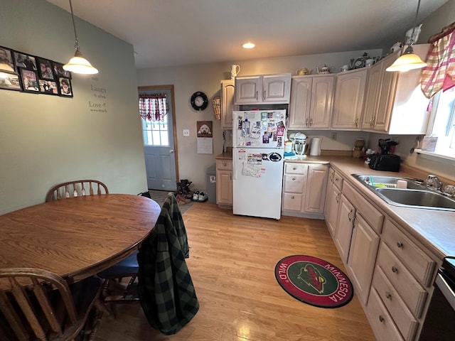 kitchen featuring white fridge, decorative light fixtures, plenty of natural light, and sink