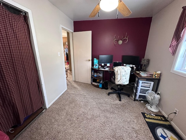 carpeted office space featuring ceiling fan