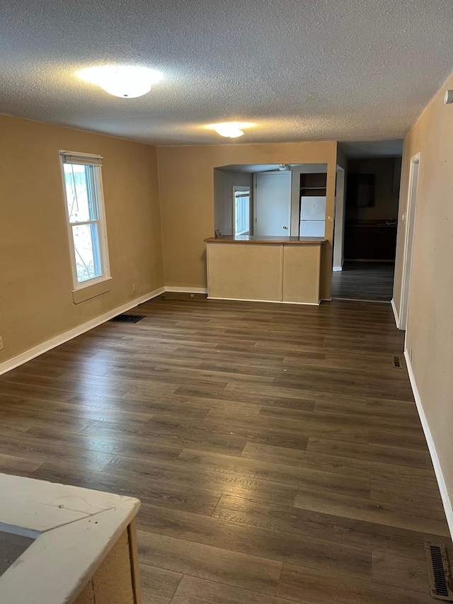 spare room with dark wood-type flooring and a textured ceiling