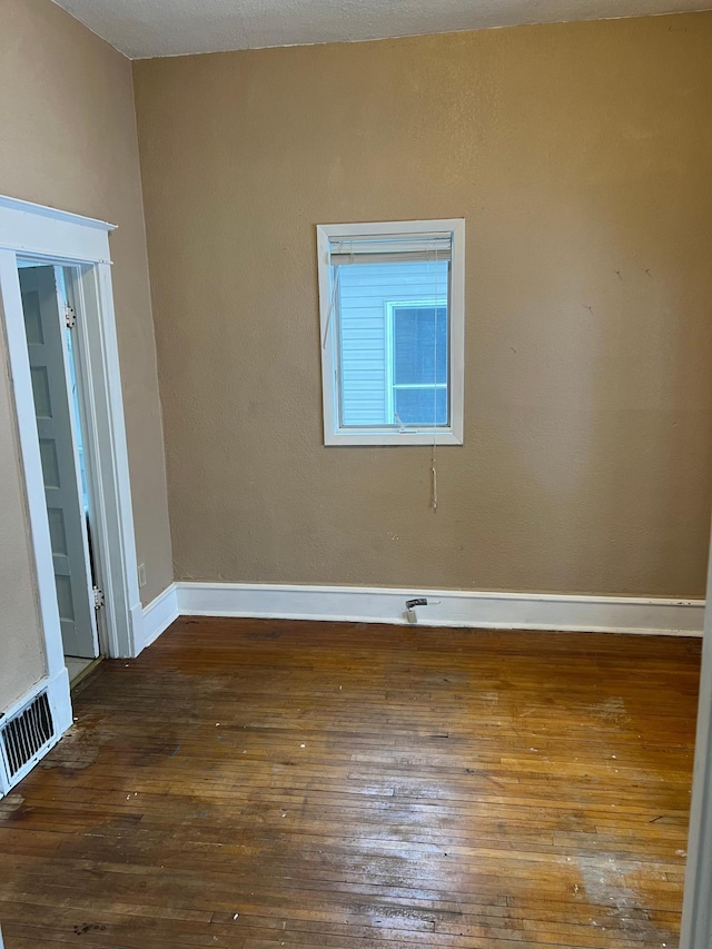 spare room with dark wood-type flooring