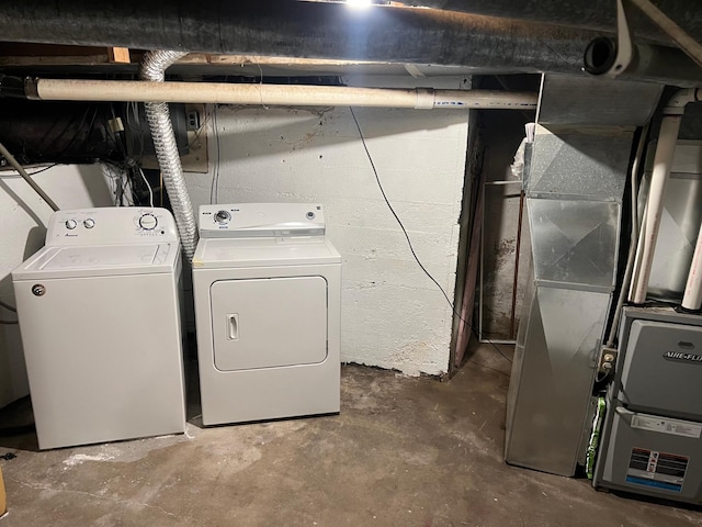 laundry room with heating unit and washer and clothes dryer