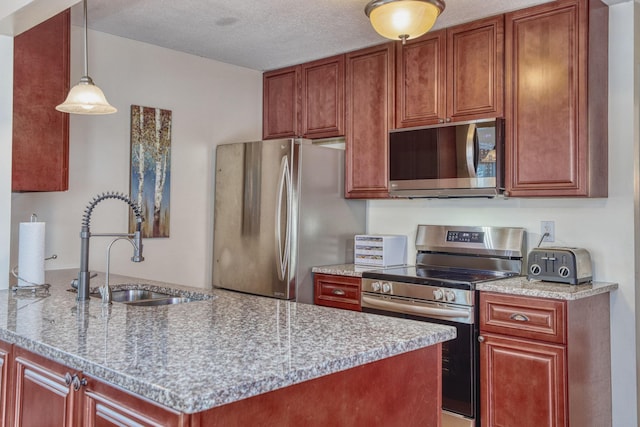 kitchen with a toaster, appliances with stainless steel finishes, decorative light fixtures, a textured ceiling, and a sink