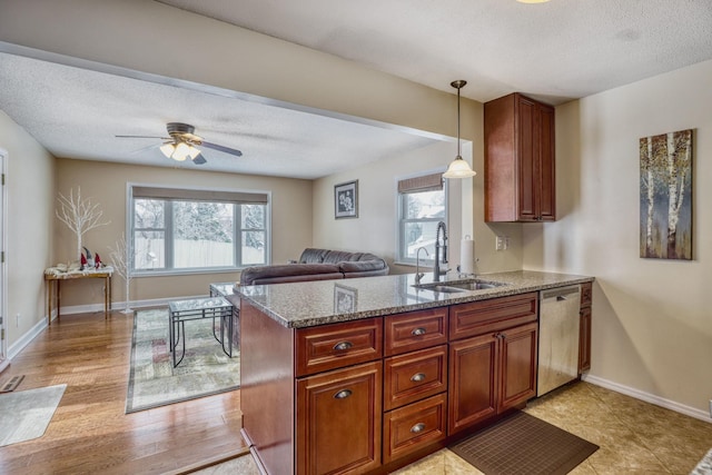 kitchen featuring a healthy amount of sunlight, a sink, a peninsula, and dishwasher