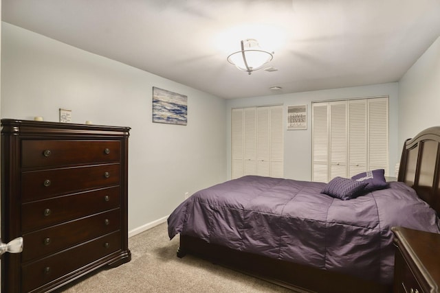 bedroom featuring baseboards, carpet flooring, and multiple closets