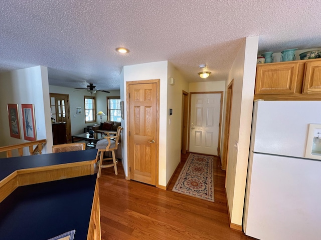 kitchen featuring white refrigerator, wood-type flooring, ceiling fan, and a textured ceiling