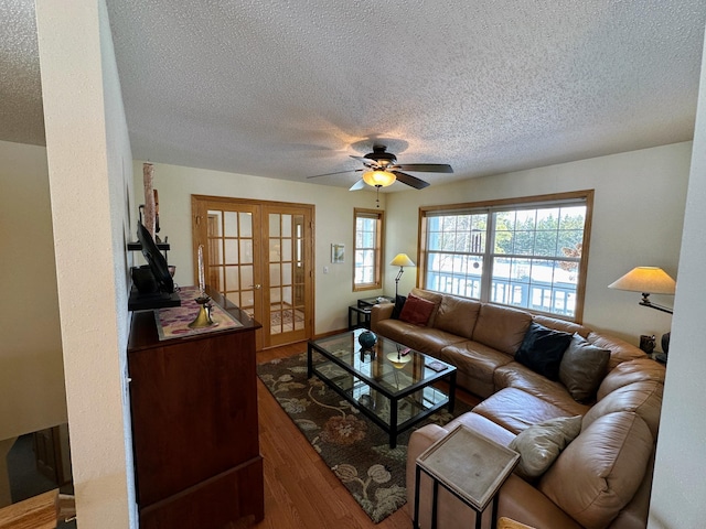 living room featuring hardwood / wood-style floors, a textured ceiling, french doors, and ceiling fan