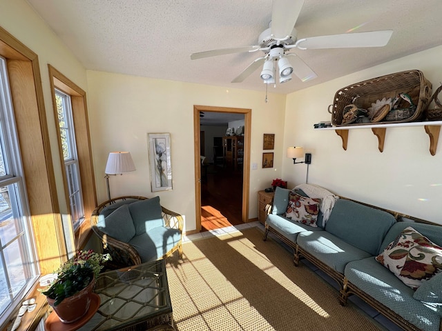 living room with ceiling fan and a textured ceiling