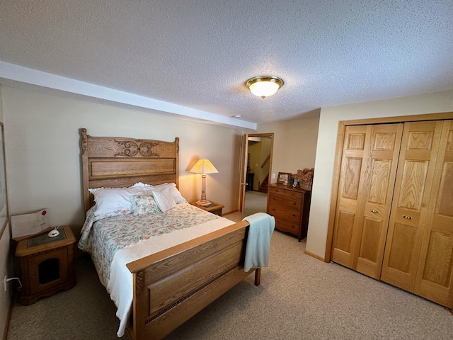 bedroom with light colored carpet, a closet, and a textured ceiling