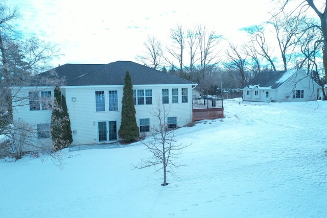 snow covered rear of property featuring a wooden deck