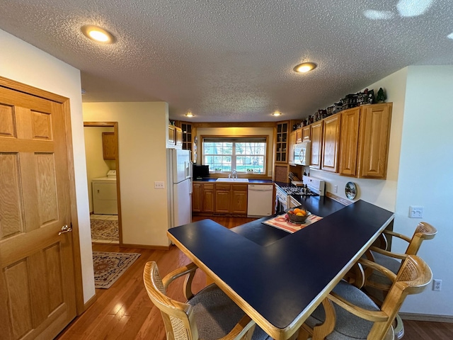 43561 Paul Lake Dr, Edna Twp, MN 56573 - kitchen featuring white appliances, washer / clothes dryer, a sink, a textured ceiling, and brown cabinets