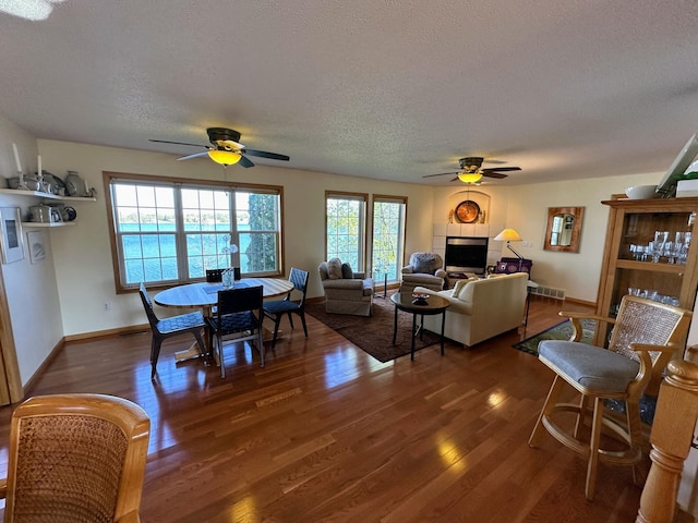 43561 Paul Lake Dr, Edna Twp, MN 56573 - dining space with ceiling fan, a textured ceiling, dark wood finished floors, and baseboards