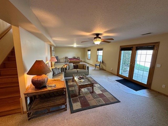 43561 Paul Lake Dr, Edna Twp, MN 56573 - carpeted living room with a ceiling fan, a textured ceiling, stairway, baseboards, and french doors