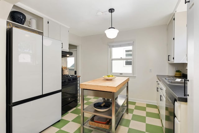 kitchen with sink, white refrigerator, black gas stove, pendant lighting, and white cabinets