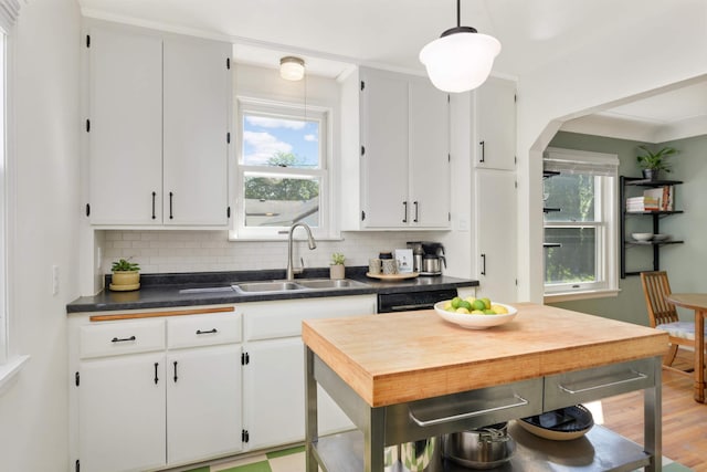 kitchen with pendant lighting, sink, backsplash, and white cabinets