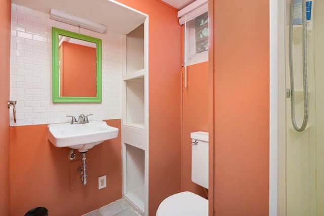 bathroom featuring sink, toilet, and a shower