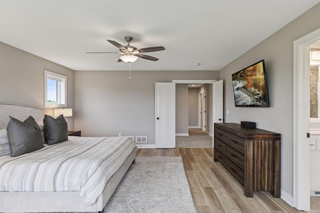 29135 Scenic Dr, Chisago City, MN 55013 - bedroom with light wood-type flooring, ensuite bathroom, and ceiling fan