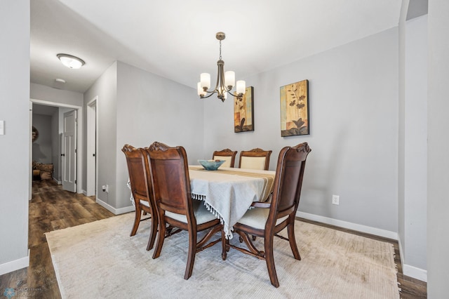 dining room featuring dark wood-type flooring and a notable chandelier