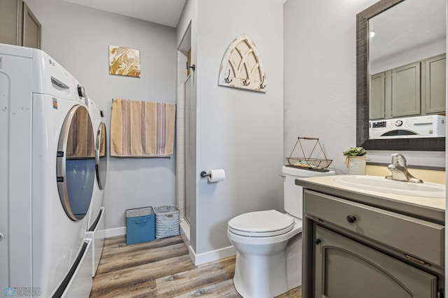 bathroom with a shower with door, vanity, hardwood / wood-style floors, and toilet