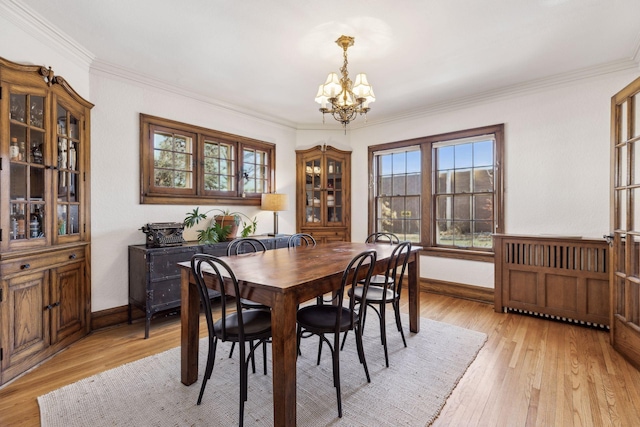 dining space with crown molding, light hardwood / wood-style flooring, and a notable chandelier