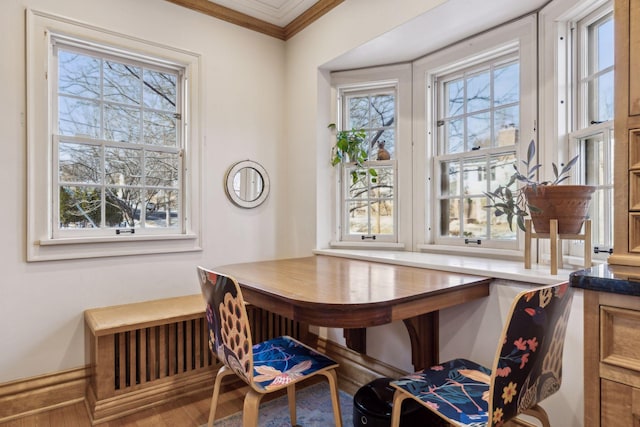 dining area with hardwood / wood-style flooring and crown molding