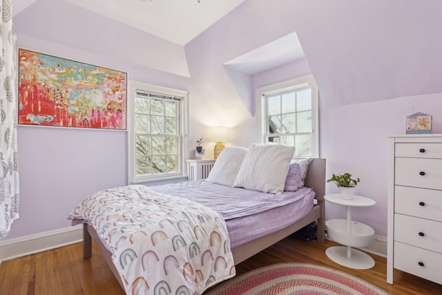 bedroom with dark hardwood / wood-style flooring, multiple windows, and vaulted ceiling