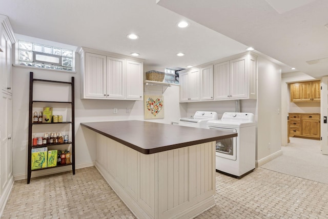 washroom with cabinets and washing machine and dryer