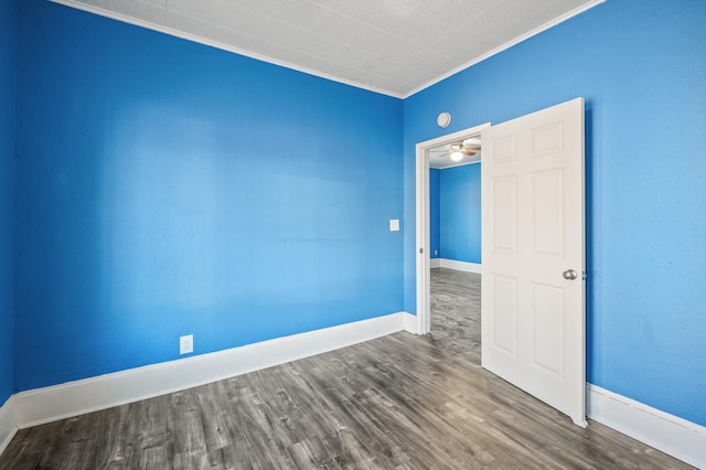 spare room with crown molding and wood-type flooring