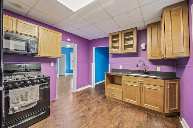 kitchen with sink, a drop ceiling, dark hardwood / wood-style floors, and black appliances