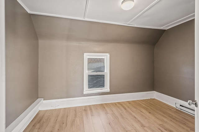 additional living space with baseboard heating, lofted ceiling, and light hardwood / wood-style floors