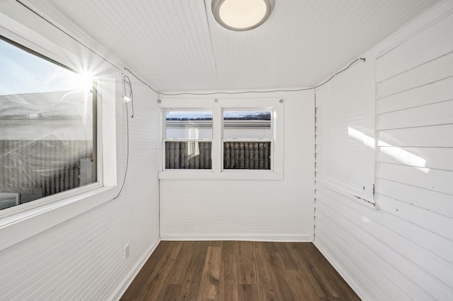 empty room featuring dark hardwood / wood-style flooring and wood walls