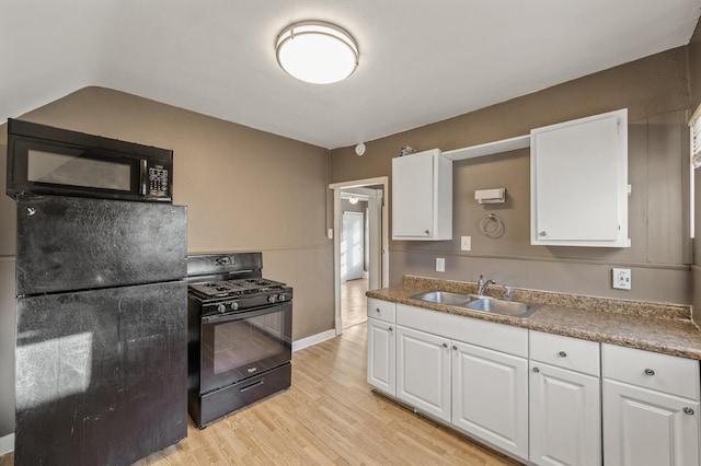 kitchen with white cabinetry, sink, black appliances, and light wood-type flooring